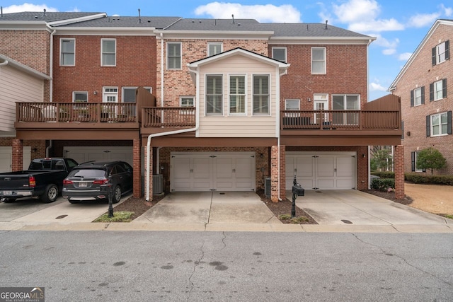 back of house with a garage, brick siding, and driveway