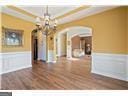 4335 Lakeside Blvd, Monroe, GA 30655 - unfurnished dining area featuring arched walkways, a wainscoted wall, a chandelier, and wood finished floors