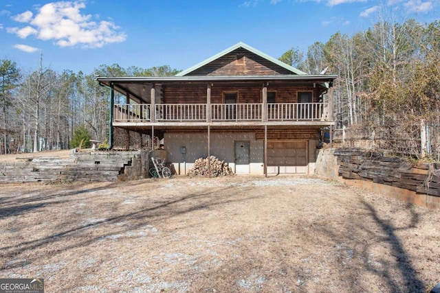 log home with dirt driveway, an attached garage, and log siding