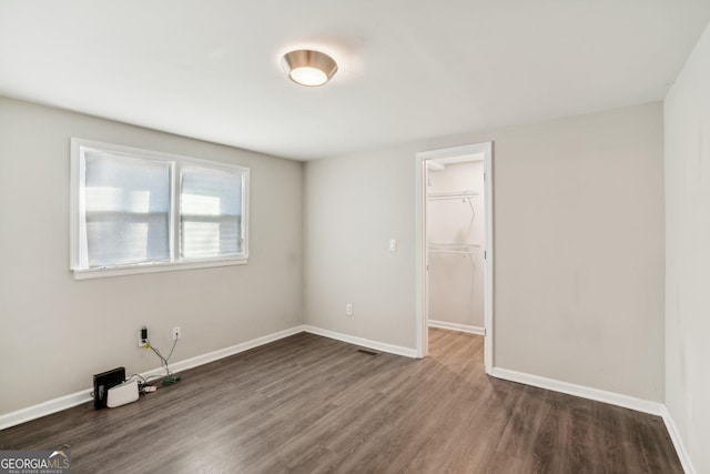 empty room featuring visible vents, baseboards, and wood finished floors