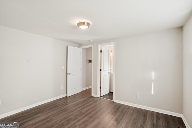 unfurnished bedroom featuring dark wood-type flooring and baseboards