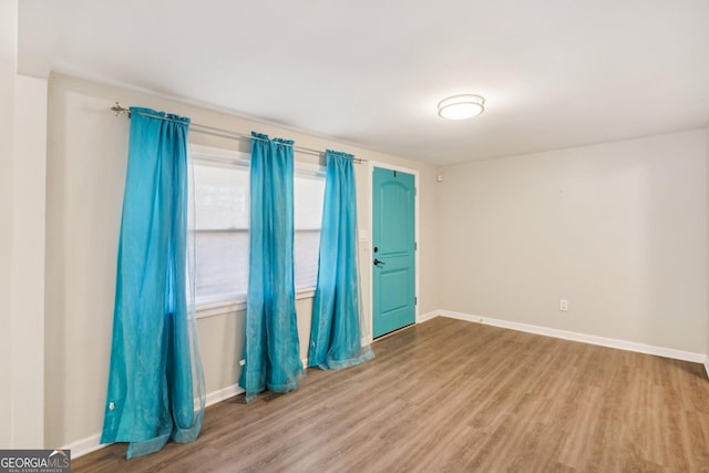 empty room featuring baseboards and wood finished floors