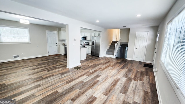 kitchen with open floor plan, stainless steel appliances, dark wood finished floors, and visible vents