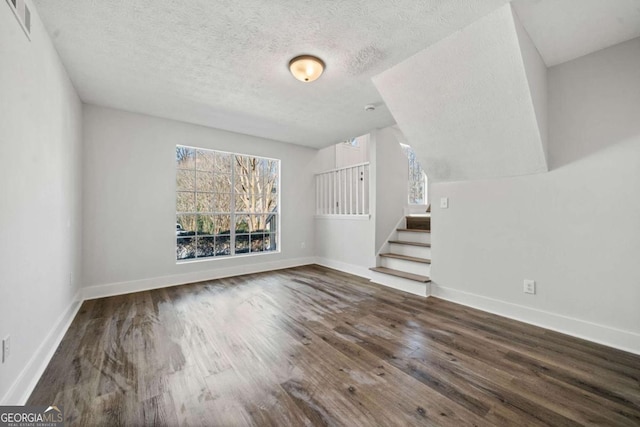 2111 Glenwood Downs Dr, Decatur, GA 30035 - unfurnished living room with healthy amount of natural light, wood finished floors, stairway, and a textured ceiling