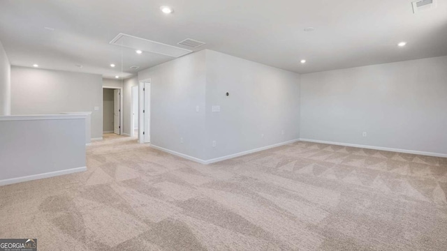 empty room featuring recessed lighting, visible vents, attic access, light carpet, and baseboards