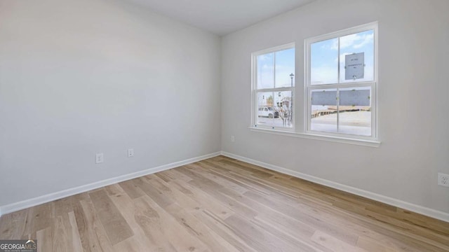 empty room with baseboards and light wood finished floors