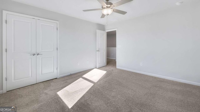 unfurnished bedroom featuring ceiling fan, a closet, baseboards, and carpet flooring