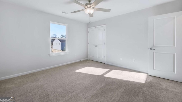 unfurnished bedroom with carpet floors, a closet, visible vents, ceiling fan, and baseboards