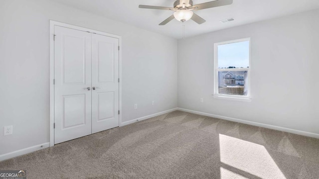 unfurnished bedroom featuring baseboards, a closet, visible vents, and carpet flooring