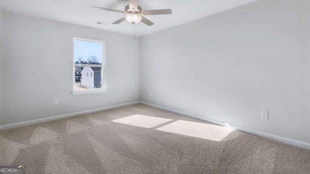 empty room featuring carpet floors, baseboards, visible vents, and ceiling fan