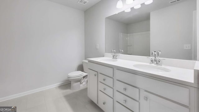 bathroom featuring toilet, double vanity, a sink, and visible vents