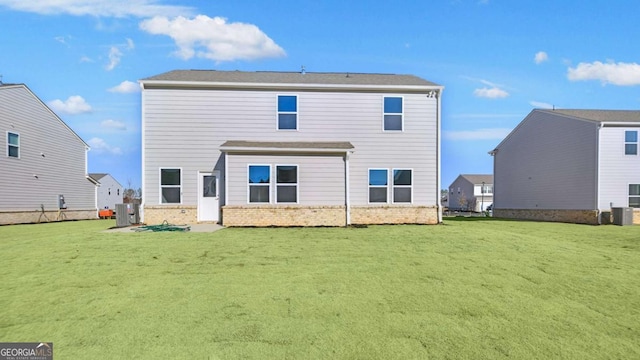 back of property with brick siding, a yard, and central AC unit