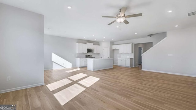 unfurnished living room with a ceiling fan, recessed lighting, visible vents, and light wood finished floors