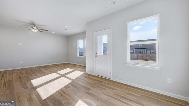 foyer entrance with baseboards, visible vents, and wood finished floors