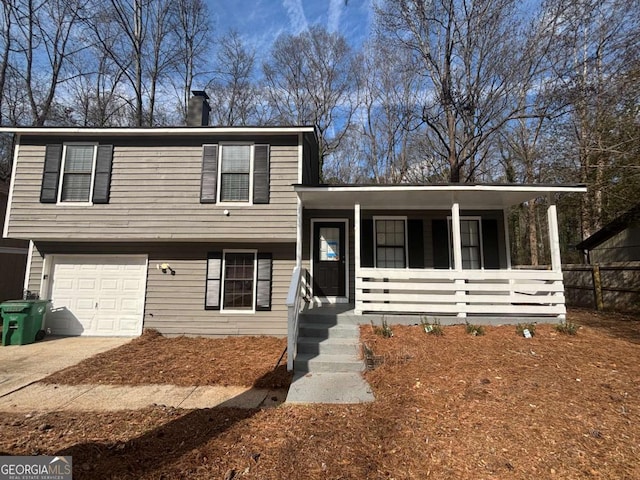 tri-level home featuring a porch, driveway, a chimney, and an attached garage