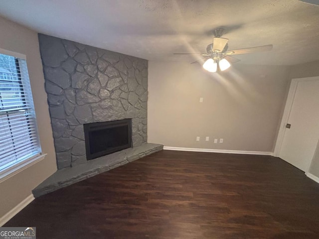 unfurnished living room featuring plenty of natural light, a fireplace, and wood finished floors