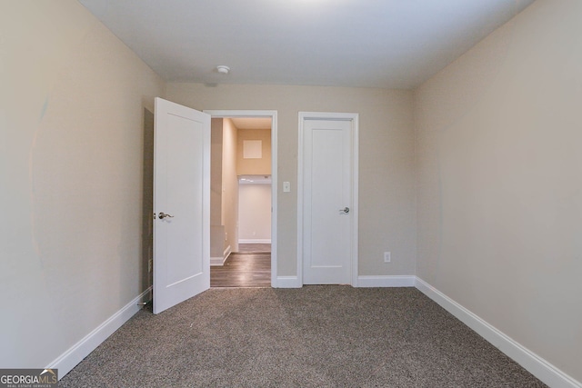 unfurnished bedroom featuring baseboards and carpet flooring