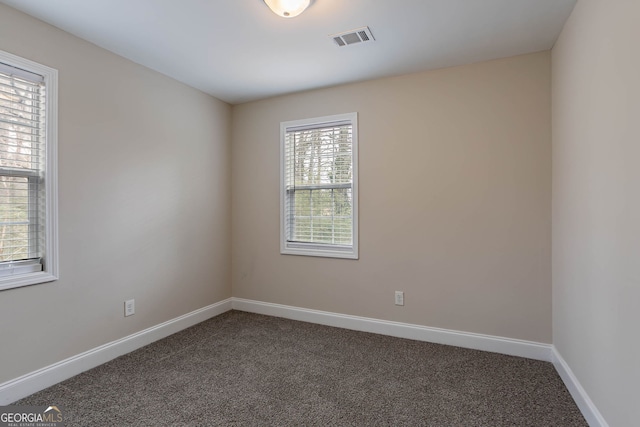 spare room with visible vents, carpet flooring, and baseboards