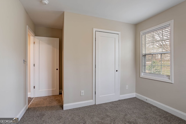 unfurnished bedroom featuring carpet and baseboards