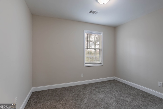 spare room with visible vents, carpet flooring, and baseboards