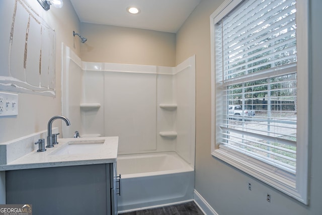 full bath featuring vanity, shower / bathtub combination, baseboards, and a wealth of natural light