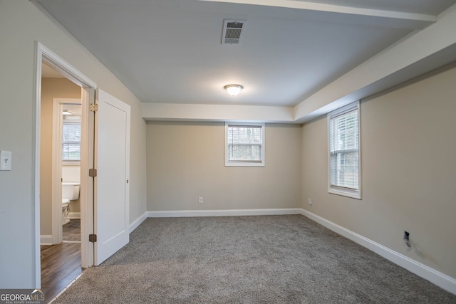 carpeted spare room with visible vents and baseboards