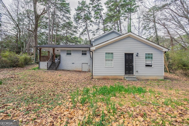 back of house featuring crawl space and brick siding