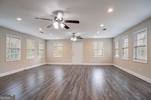 unfurnished living room featuring baseboards, visible vents, and a healthy amount of sunlight