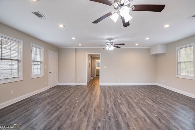 spare room featuring visible vents, baseboards, and dark wood-style flooring