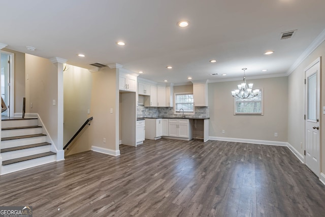 unfurnished living room with visible vents, dark wood-type flooring, and a sink