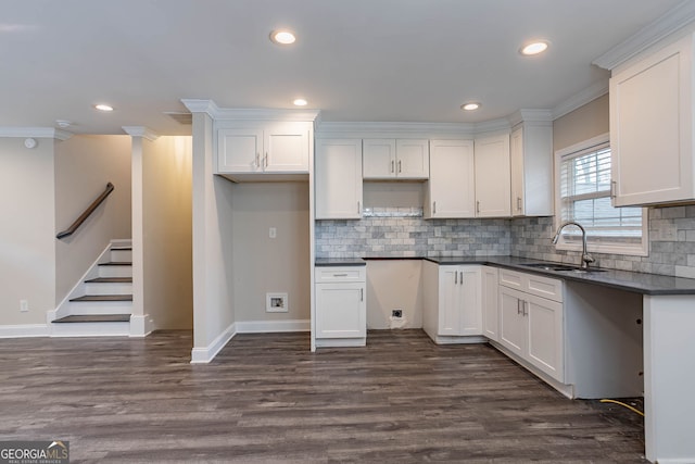 kitchen with a sink, dark countertops, dark wood finished floors, and white cabinets
