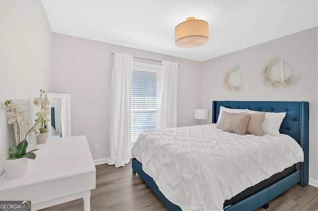 bedroom featuring wood finished floors and baseboards