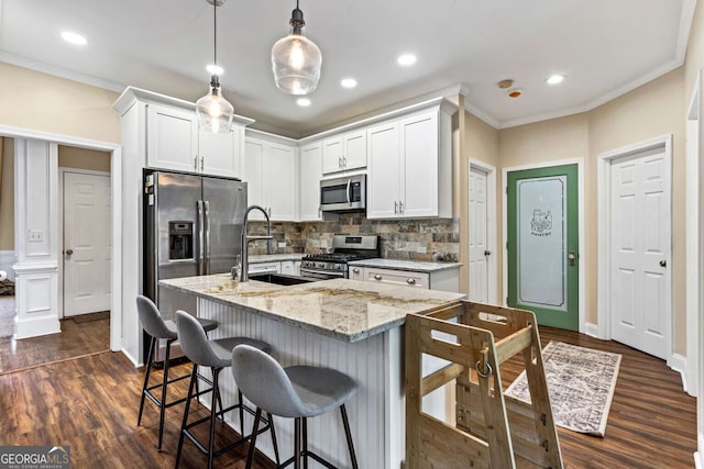 kitchen with stainless steel appliances, a breakfast bar, white cabinets, and crown molding