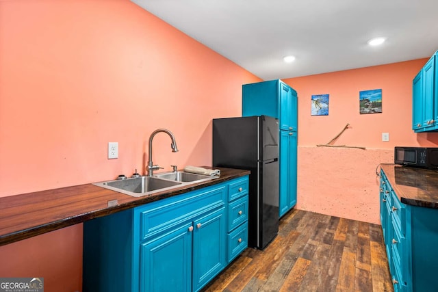 kitchen with blue cabinets, dark countertops, a sink, and black appliances