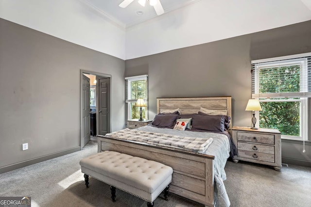 bedroom featuring baseboards, ensuite bath, ceiling fan, carpet, and crown molding