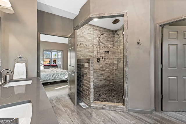 bathroom featuring ensuite bathroom, a stall shower, and a sink