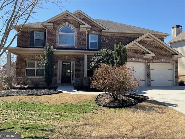 view of front of home featuring an attached garage, concrete driveway, brick siding, and a front yard