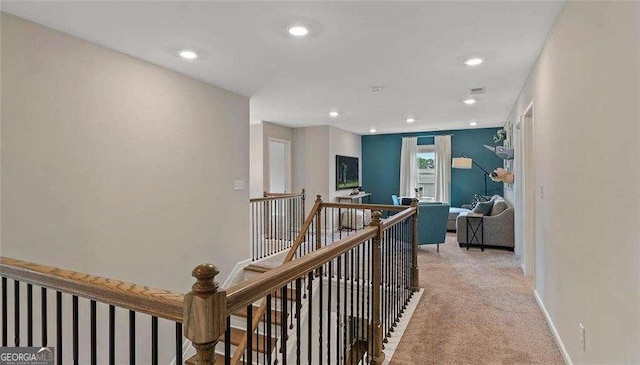 hall with recessed lighting, visible vents, light carpet, an upstairs landing, and baseboards