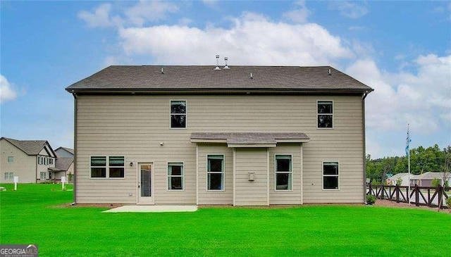 rear view of house with a patio, a lawn, and fence