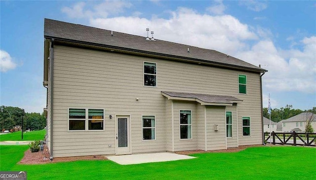 back of property with a patio area, a lawn, and fence