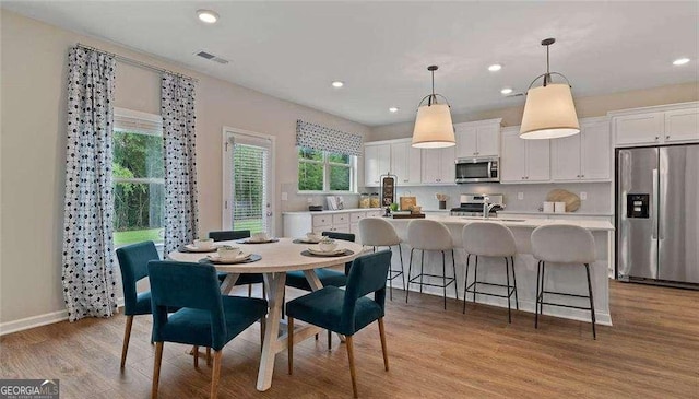 dining space with light wood-style floors, baseboards, visible vents, and recessed lighting