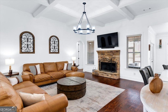 living area with coffered ceiling, a fireplace, dark wood finished floors, and an inviting chandelier