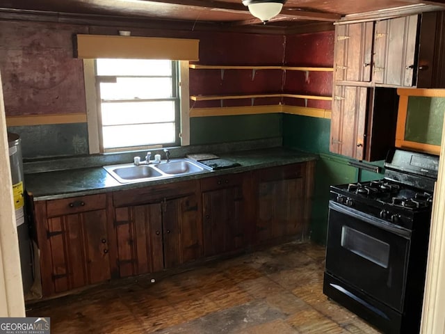 kitchen with dark countertops, a sink, and black gas range