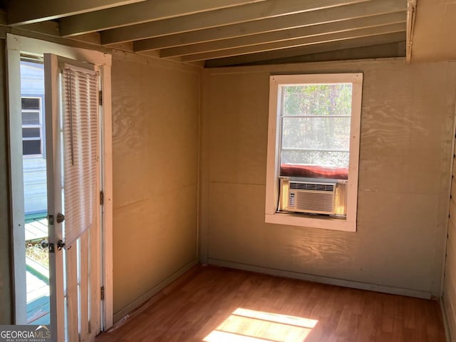 unfurnished room featuring cooling unit and wood finished floors