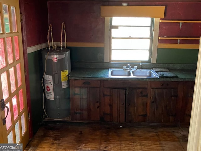 kitchen with dark countertops, water heater, and a sink