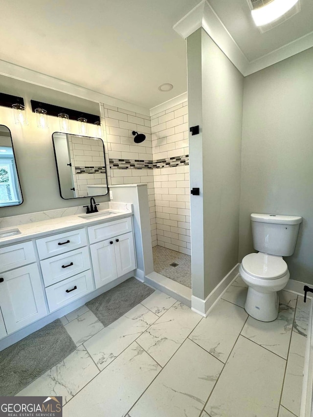 full bath featuring marble finish floor, double vanity, ornamental molding, baseboards, and walk in shower