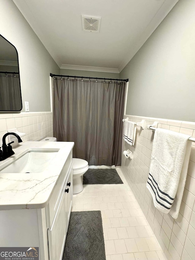 full bathroom with toilet, visible vents, tile walls, and vanity