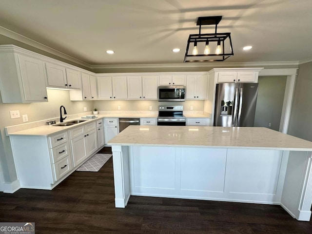 kitchen with dark wood finished floors, appliances with stainless steel finishes, white cabinets, a sink, and a kitchen island