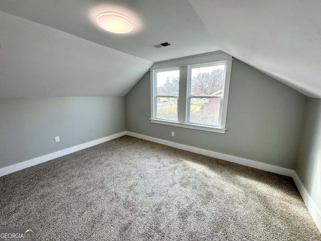 additional living space featuring lofted ceiling, carpet flooring, visible vents, and baseboards