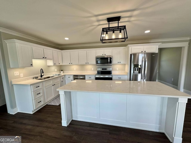 kitchen featuring stainless steel appliances, a center island, white cabinetry, and a sink